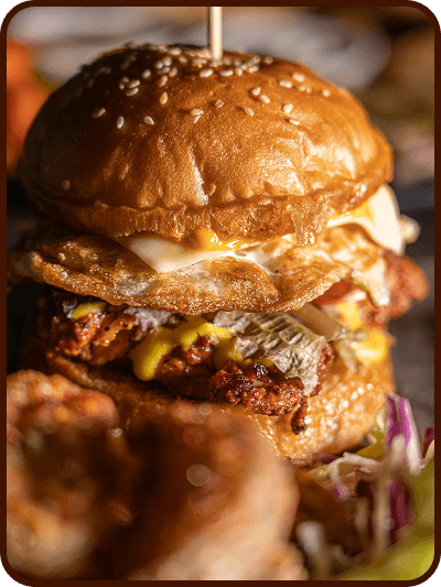 A stacked fried chicken burger with a runny egg